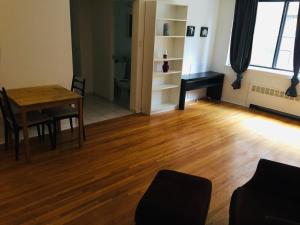 een woonkamer met een houten tafel en een bureau bij Stylish Montreal Apartment: Comfortable Stay in the Golden Square Mile in Montreal