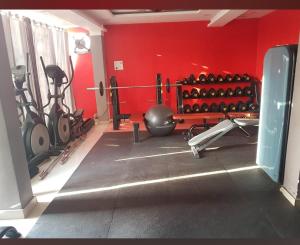 um ginásio com muitos equipamentos de exercício numa parede vermelha em Hotel Sarvapriya em Chopan