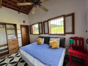 1 dormitorio con 1 cama con sábanas azules y almohadas amarillas en EcoRanch Chez Nous Deux, en El Socorro