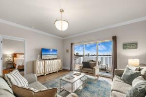 Una sala de estar con un sofá y un televisor. en South Harbour Unit 3D, en Pensacola Beach