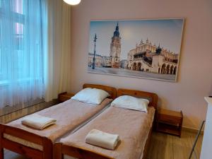 2 camas en una habitación con una foto en la pared en Apartament Różana przy ICE, en Cracovia
