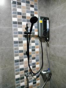 La salle de bains est pourvue d'une douche et d'un téléphone. dans l'établissement Hana Villa Hatyai, à Suen Phra