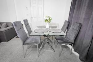 a dining room with a glass table and chairs at Comfy 2 Bedroom House for 4 in Strood