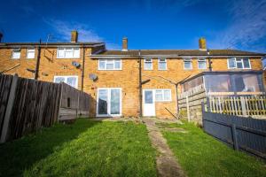 a brick house with a fence in front of it at Comfy 2 Bedroom House for 4 in Strood