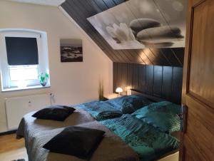 a bedroom with a bed with a comforter and a ceiling at Ferienwohnung Am Vulkanpfad in Ettringen