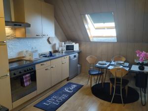 a kitchen with a small table and a kitchen with a window at Ferienwohnung Am Vulkanpfad in Ettringen