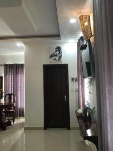 uma sala de estar com uma porta preta e uma mesa em Liza Boutique em Phumĭ Ta Phŭl