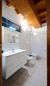 ein weißes Bad mit einem Waschbecken und einem WC in der Unterkunft Domus Dea 4 Città Alta in Bergamo