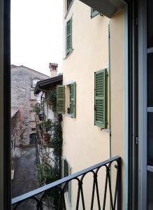 einen Blick vom Balkon eines Gebäudes mit grünen Rollläden in der Unterkunft Domus Dea 4 Città Alta in Bergamo