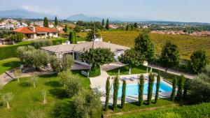 una vista aérea de una casa con piscina y árboles en Villa Carini with 3000 mq garden & heated pool, en Castelnuovo del Garda