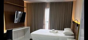 a hotel room with a bed and a television at VISION HOTEL Brasilia Piscina Academia Garagem Flat 12 Andar in Brasília