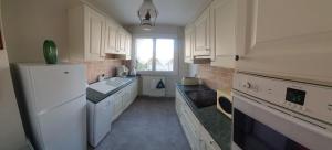 a kitchen with a white refrigerator and a sink at Chemin vert in Bayeux