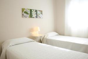 En eller flere senger på et rom på Apartamento con Terraza Grande 1 Línea Playa Almadrava