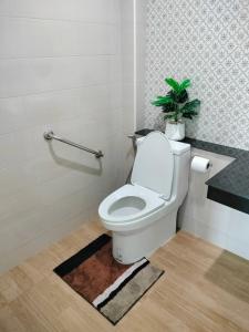 a bathroom with a toilet with a plant on it at Hana Villa Hatyai in Suen Phra