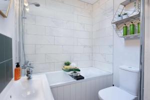 a bathroom with a tub and a sink and a toilet at Cosy Cottage, Central Ludlow, Free Parking, Boutique Hotel Style in Ludlow