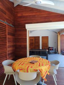 Un comedor con mesa y sillas en Lodge belle nature, piscine privée, grand jardin, 900 m de la plage de grande anse, en Deshaies