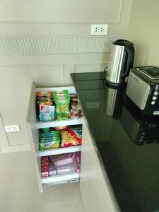 a kitchen counter with a refrigerator with food at Hana Villa Hatyai in Suen Phra