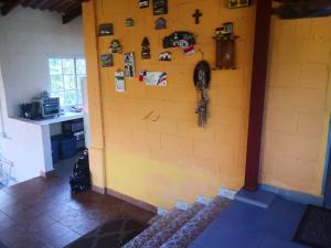 a room with a yellow wall with a cross on it at Sonidos de la Naturaleza!! in Los Altos de Cerro Azul