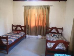 two beds sitting in a room with a window at Sonidos de la Naturaleza!! in Los Altos de Cerro Azul