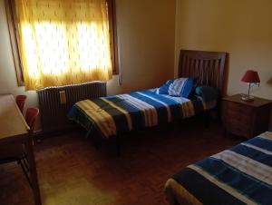 a hotel room with two beds and a window at Bons Aires in Llivia