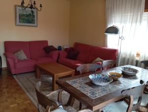 a living room with a red couch and a table at Bons Aires in Llivia