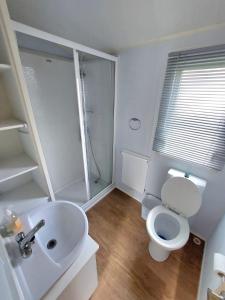 een witte badkamer met een toilet en een wastafel bij Haven holiday park Cleethorpes beach in Cleethorpes