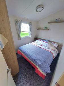 a small bedroom with a bed and a window at Haven holiday park Cleethorpes beach in Cleethorpes