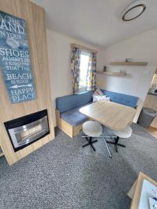 a living room with a blue couch and a table at Haven holiday park Cleethorpes beach in Cleethorpes