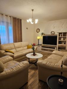 een woonkamer met banken en een flatscreen-tv bij Apartments Vraneš Tivat in Tivat