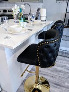 two black chairs sitting at a counter in a kitchen at 2BR-2BA Luxy Dendrobium Oasis, Pet Friendly, Family Friendly, Free Parking & Balcony in Philadelphia
