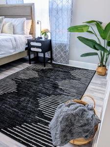 a bedroom with a bed and a black rug at 2BR-2BA Luxy Dendrobium Oasis, Pet Friendly, Family Friendly, Free Parking & Balcony in Philadelphia