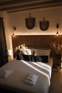 a bedroom with a large bed with towels on it at NISOS Home Stay in Mýkonos City