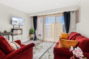 a living room with red furniture and a window at 2BR-2BA Luxy Dendrobium Oasis, Pet Friendly, Family Friendly, Free Parking & Balcony in Philadelphia