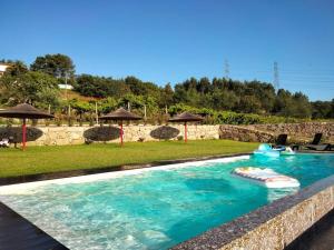 a swimming pool with a water slide in a yard at Penedo Village in Marco de Canaveses