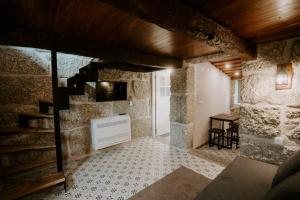 a living room with a fireplace and a staircase at Penedo Village in Marco de Canaveses