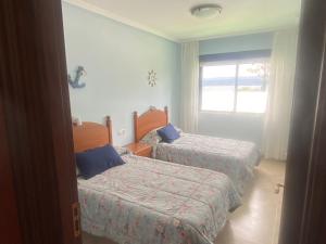 Posteľ alebo postele v izbe v ubytovaní Apartamentos Playa Langosteira