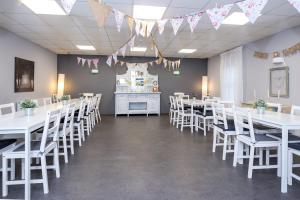 une salle à manger avec des tables et des chaises blanches dans l'établissement Podumna Glamping Village, à Portumna