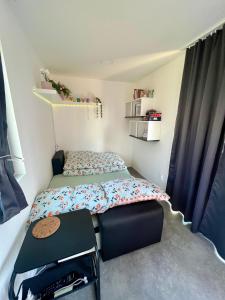 a small bedroom with a bed and a table at Bobule v sudu in Bořetice