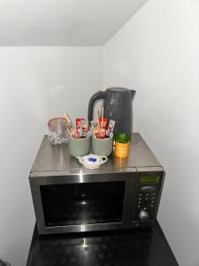 a microwave with bowls and a coffee pot on top of it at P&S rooms guesthouse Lincoln city centre in Lincolnshire