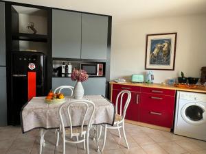 a kitchen with a table with a vase of flowers on it at Logement entier de charme, gite équestre GERS Flamarens in Flamarens