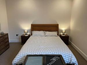 a bedroom with a large bed with two night stands at Home comfort 4 mins from Gatwick! in Horley