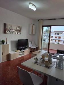 un salon avec une table et une télévision dans l'établissement ¡Piso familiar en Jávea!, à Jávea