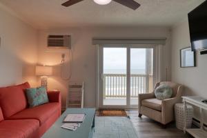 ein Wohnzimmer mit einem Sofa und einem Stuhl in der Unterkunft Oceanfront: Beach, Sand and Views at Coral Reef! in North Topsail Beach
