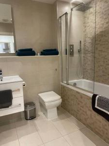 a bathroom with a toilet and a shower and a sink at Home comfort 4 mins from Gatwick! in Horley
