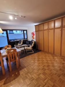 a living room with wooden cabinets and a table and chairs at Ferienwohnung Hedy in Prien am Chiemsee