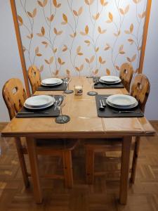 a wooden table with chairs and plates on it at Ferienwohnung Hedy in Prien am Chiemsee