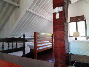 1 dormitorio con 2 camas y reloj en una pared de ladrillo en Cabañita Doña Tina, en Los Altos de Cerro Azul