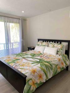 - une chambre dotée d'un grand lit avec un couvre-lit floral dans l'établissement Poplar Place by the Lake with Hot Tub, à Fenelon Falls