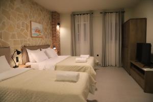 a hotel room with two beds and a flat screen tv at Cruzeto in Syvota