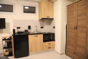 a kitchen with a black refrigerator and a microwave at Cruzeto in Syvota